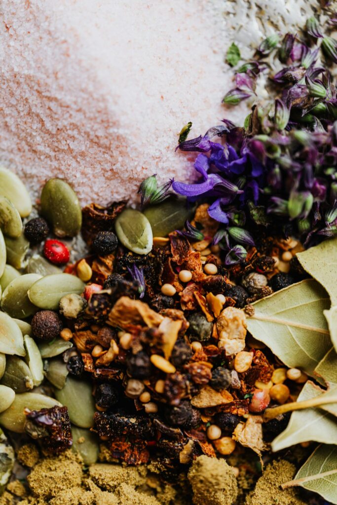 A vibrant close-up of assorted spices, seeds, and salt with herbs, perfect for culinary inspiration.